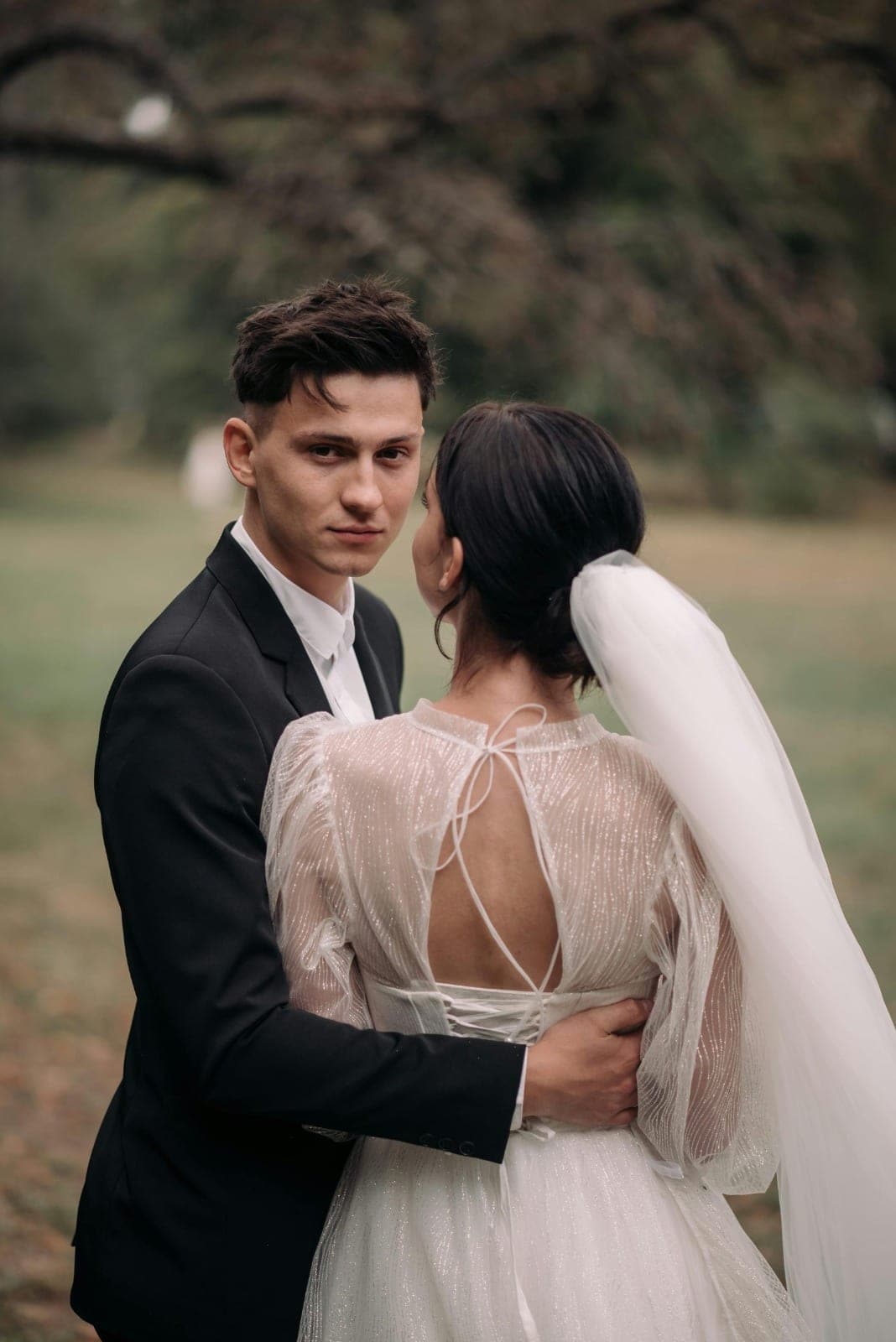 A groom smiling beside his bride