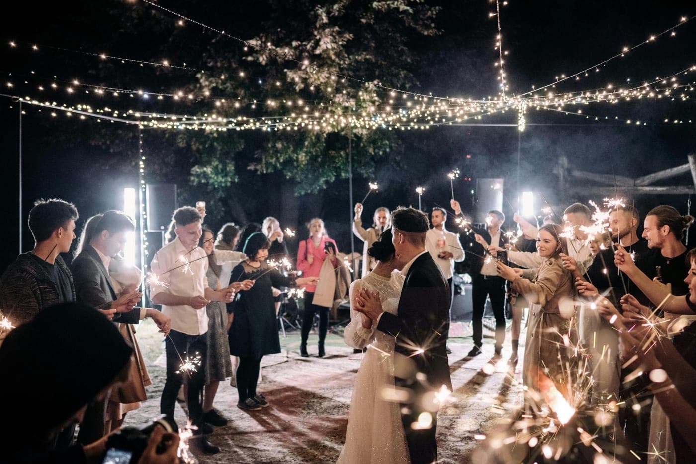Guests holding sparklers around the couple's first dance